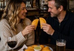 Couple sharing empanadas over wine and beer at in a pub - Illustrative Image